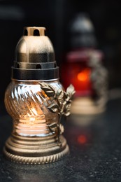 Photo of Grave light on granite surface at cemetery, closeup