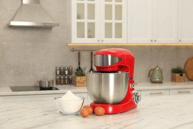 Photo of Modern red stand mixer, eggs and bowl with flour on white marble table in kitchen