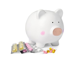 Photo of Piggy bank and pills on white background. Medical insurance