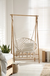 Photo of Comfortable hammock chair in stylish room. Home interior