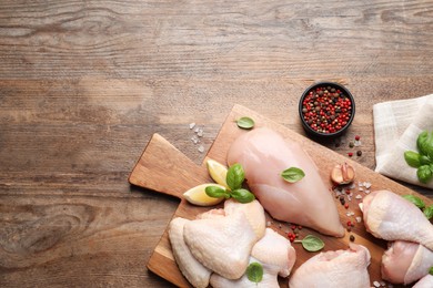 Photo of Flat lay composition with fresh raw chicken meat on wooden table. Space for text