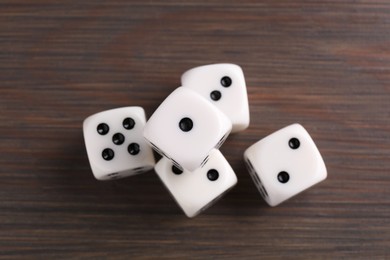 Photo of Many white game dices on wooden table, top view