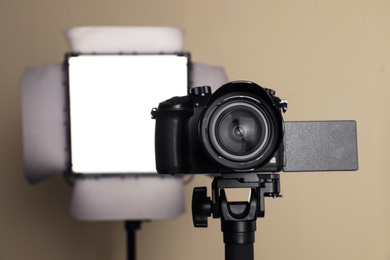 Photo of Professional video camera and lighting equipment on beige background