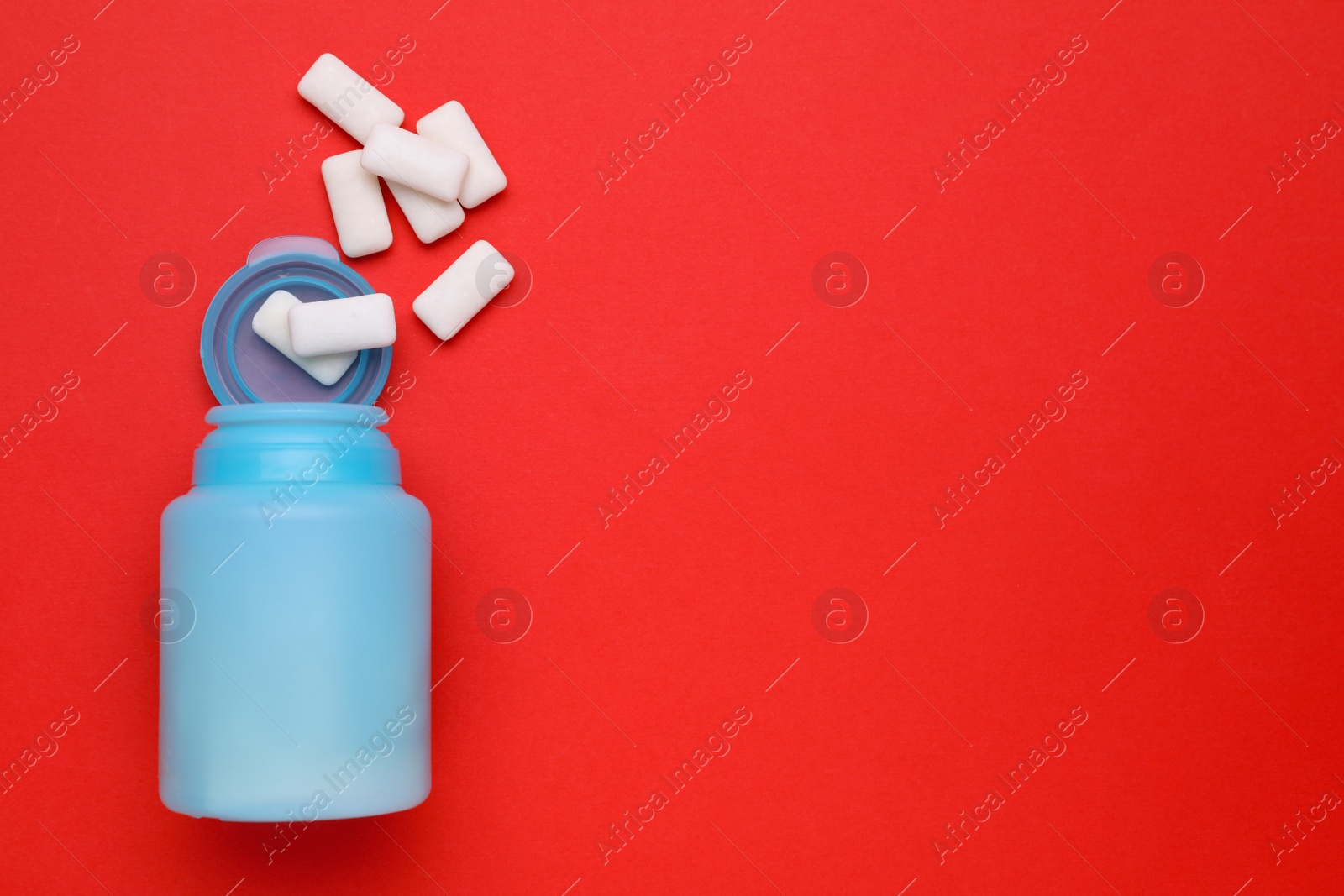 Photo of Jar with chewing gums on red background, flat lay. Space for text