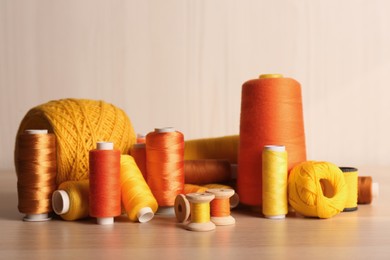 Photo of Set of color sewing threads on wooden table