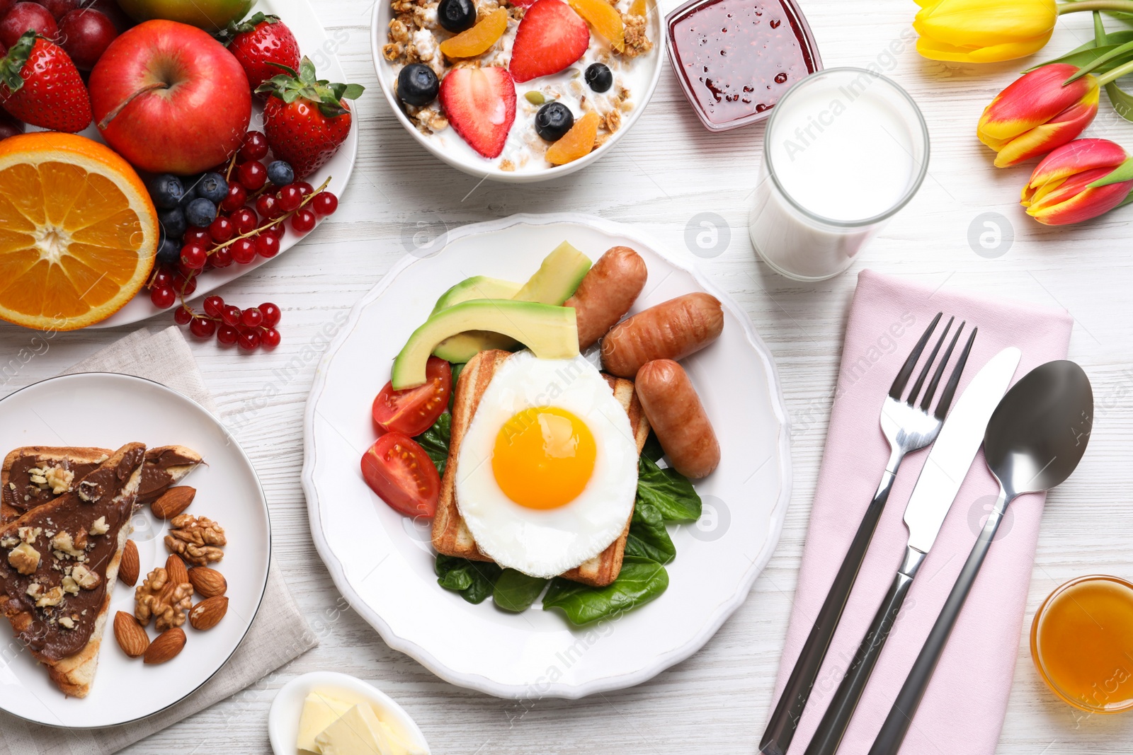 Photo of Delicious breakfast with fried egg served on white wooden table, flat lay