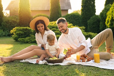 Happy family having picnic in garden on sunny day