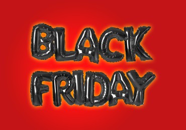 Phrase BLACK FRIDAY made of foil balloon letters on red background 