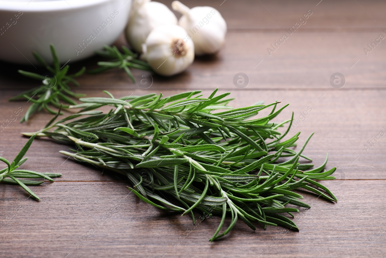 Photo of Sprigs of fresh rosemary on wooden table