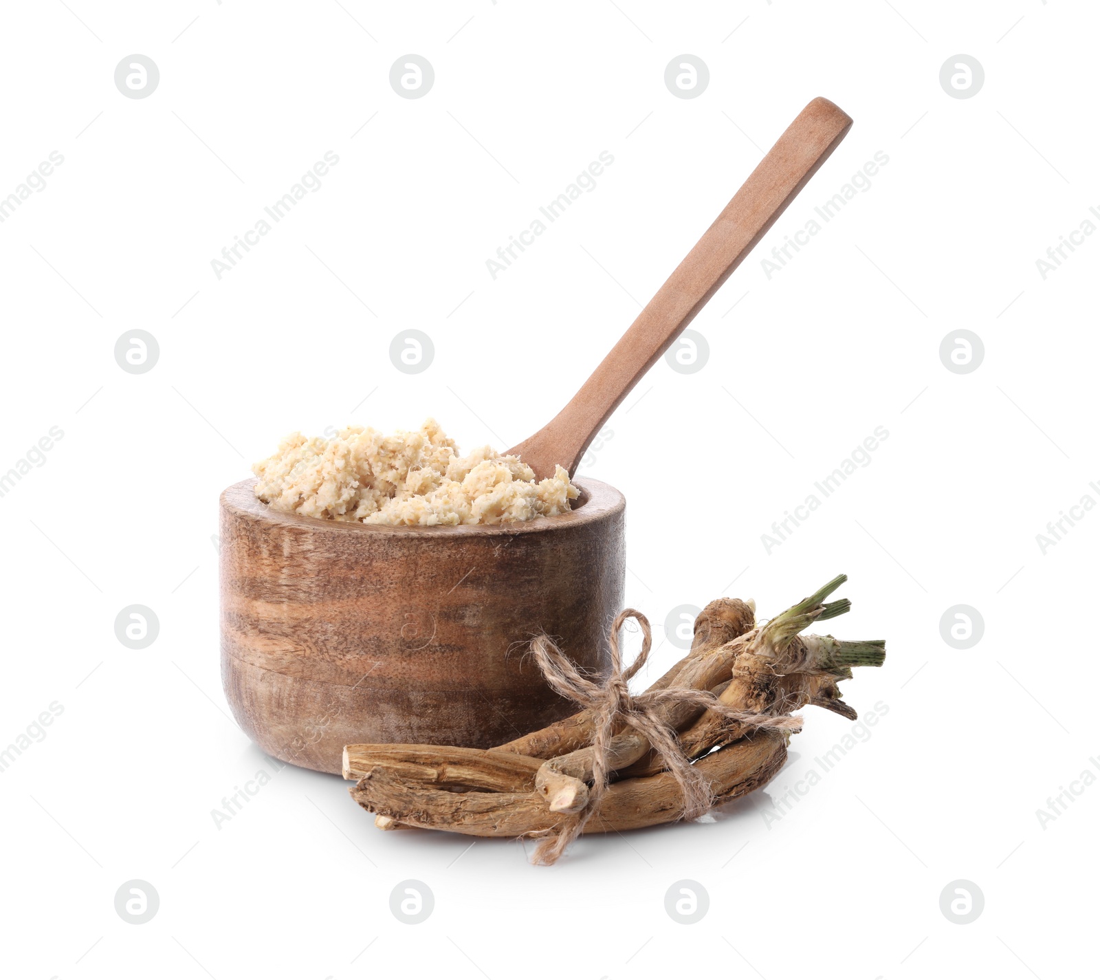 Photo of Bowl of tasty prepared horseradish, spoon and roots isolated on white