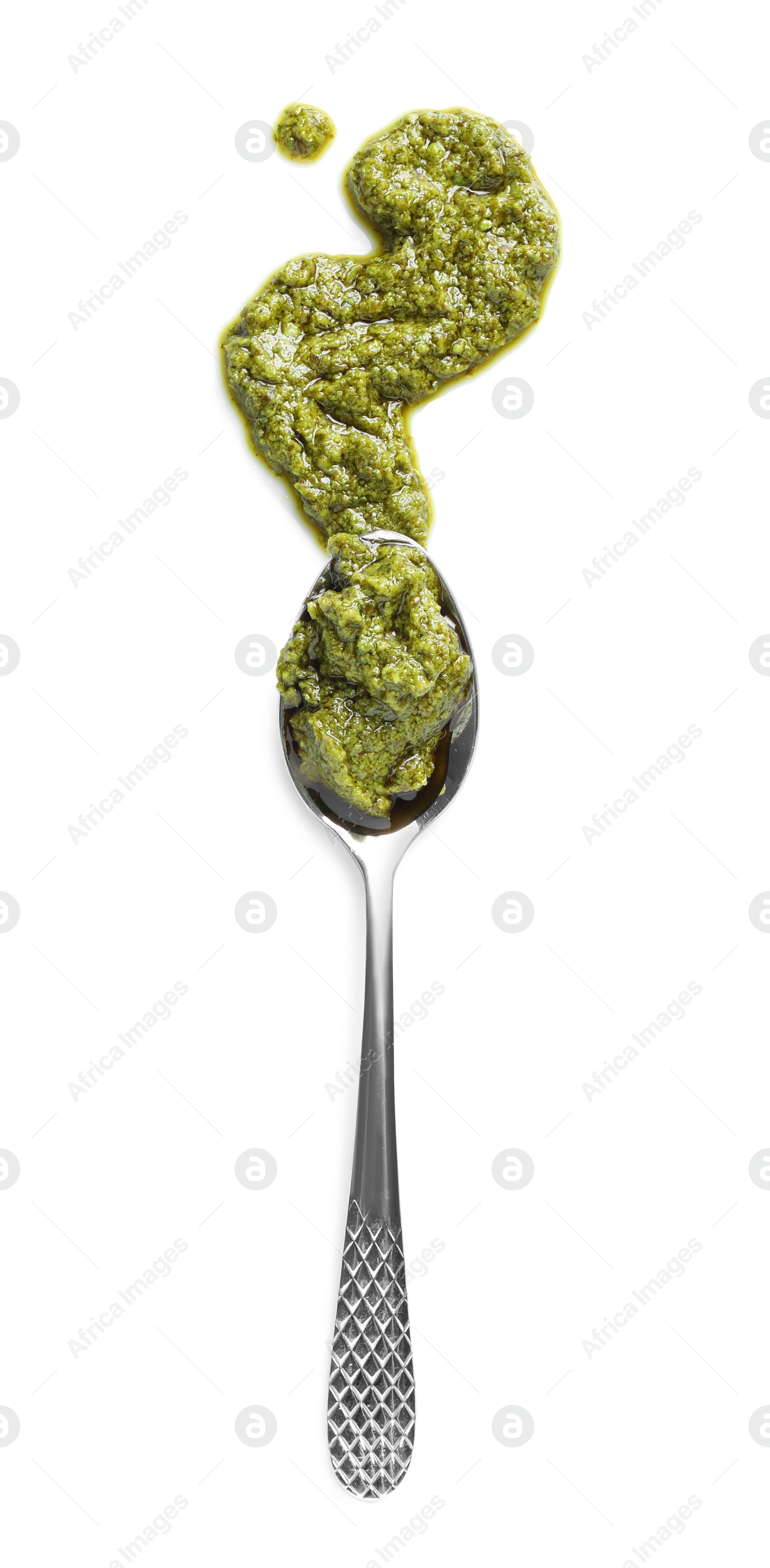 Photo of Sample of tasty pesto sauce and spoon isolated on white, top view