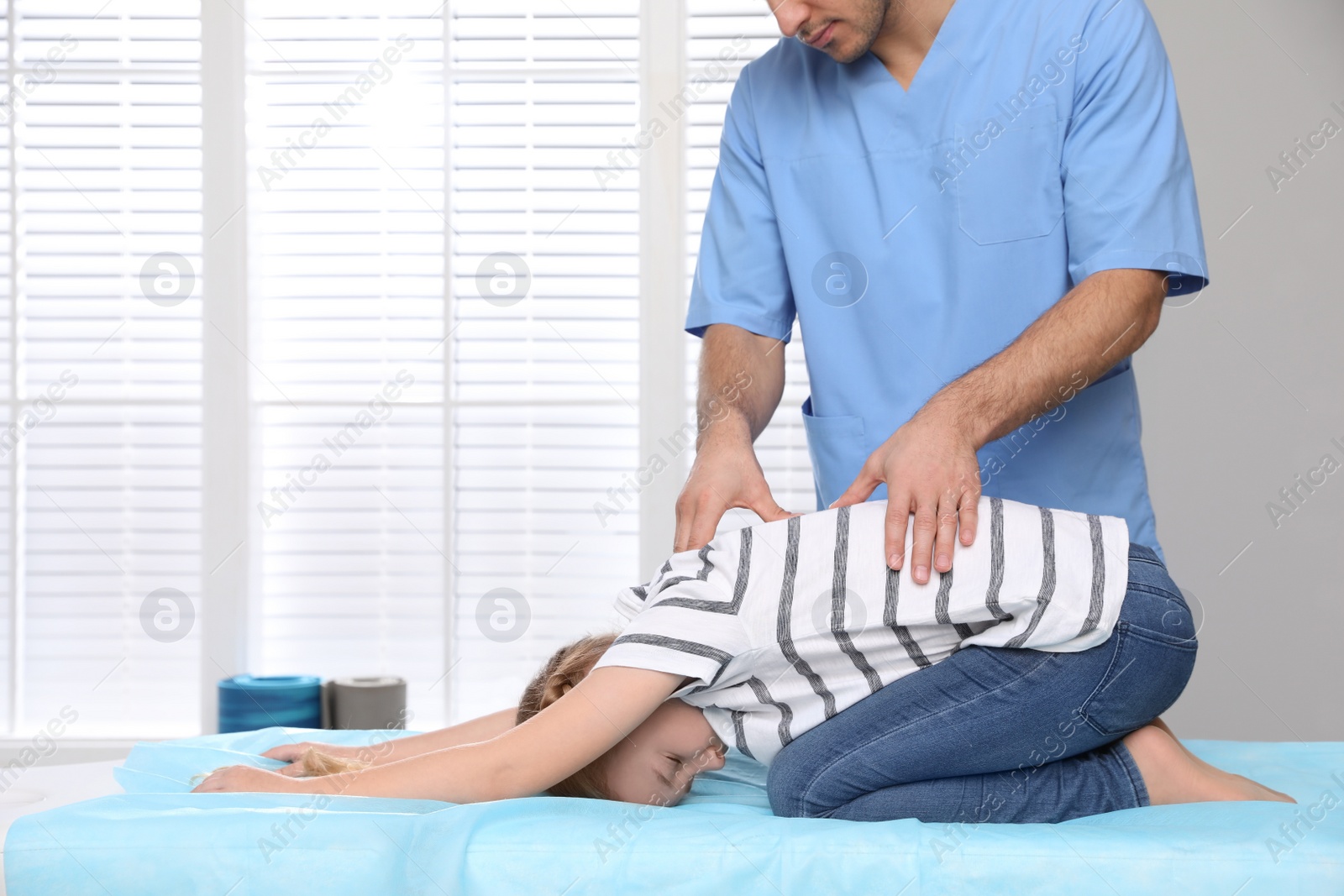 Photo of Orthopedist examining child's back in clinic, closeup. Scoliosis treatment