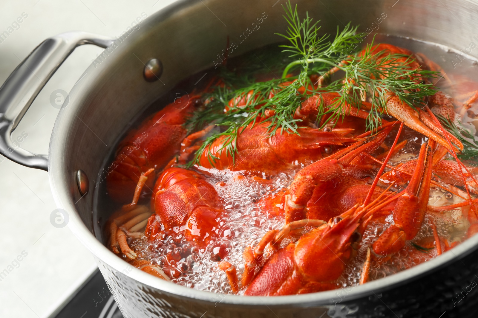 Photo of Fresh delicious crayfishes in boiling water, closeup