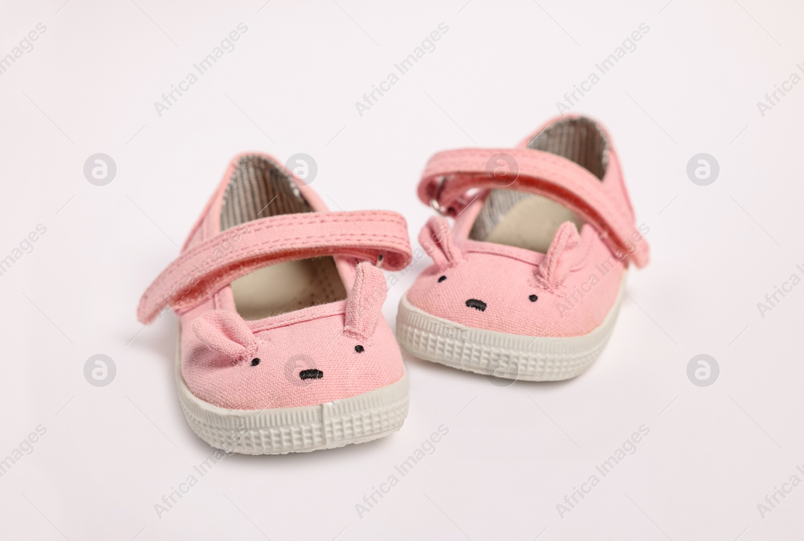 Photo of Pair of cute baby shoes on white background