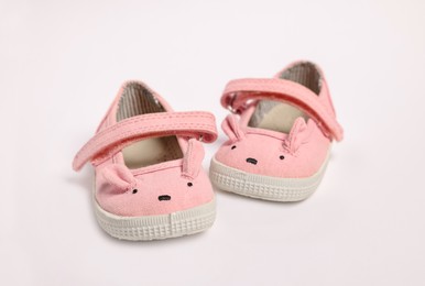 Photo of Pair of cute baby shoes on white background