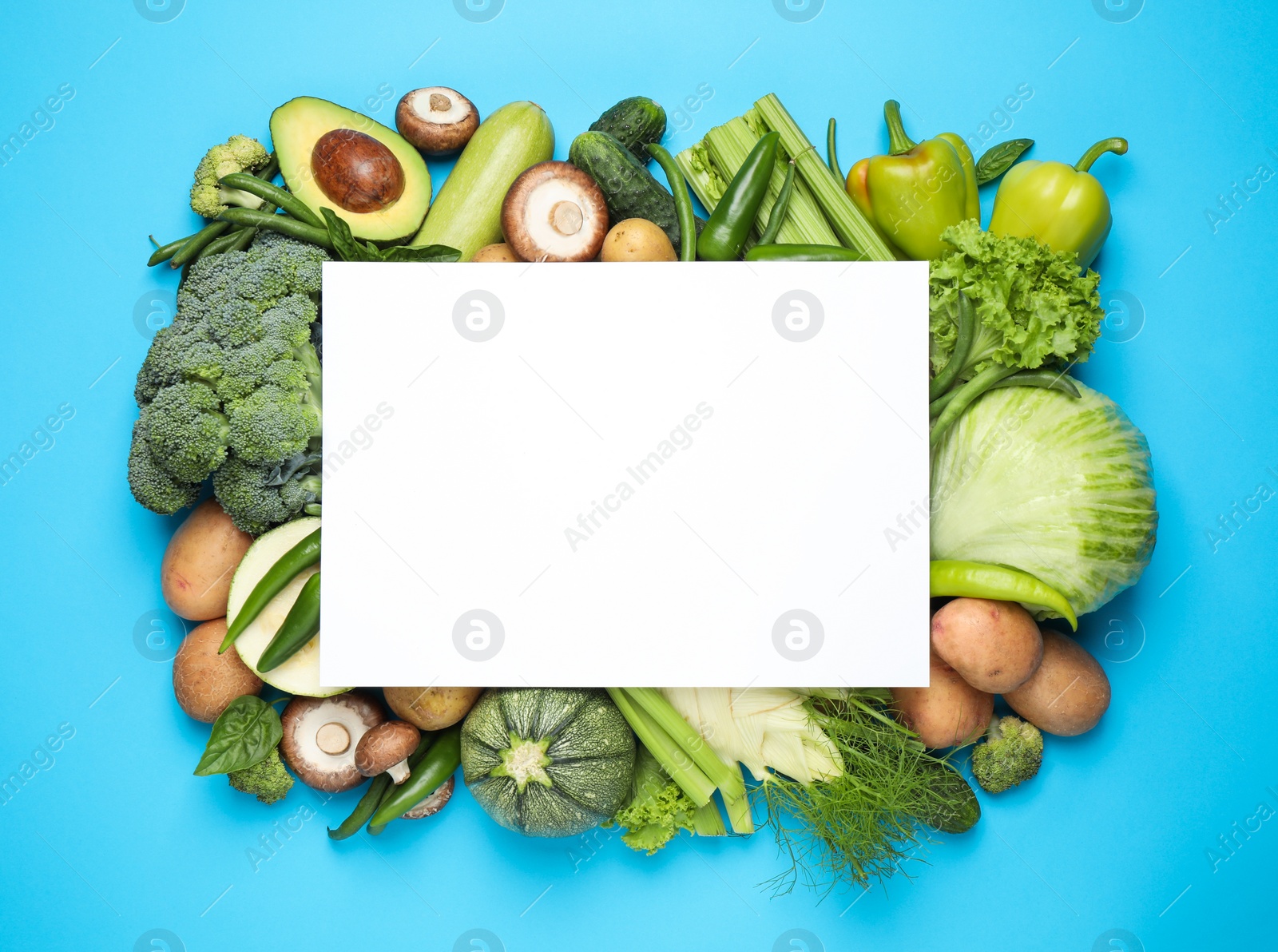 Photo of Blank card and fresh vegetables on light blue background, flat lay. Space for text