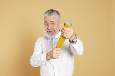 Photo of Man with party popper on beige background
