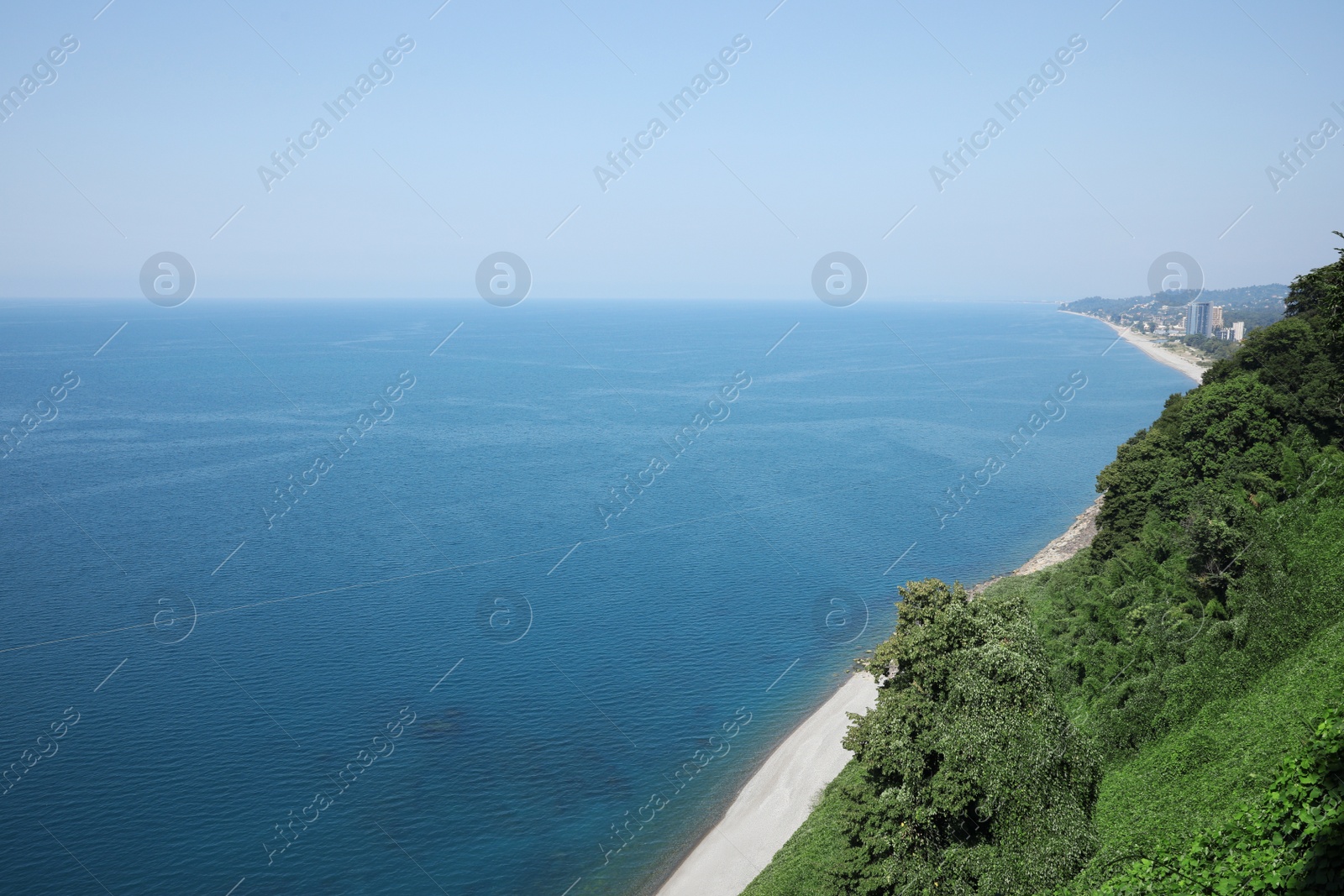 Photo of Picturesque view of green hills and sea with clear water