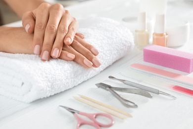 Photo of Woman waiting for manicure and tools on table, closeup with space for text. Spa treatment