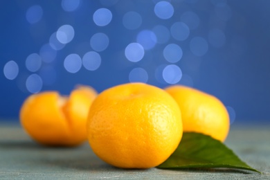 Photo of Tangerines on grey table against blurred lights, space for text