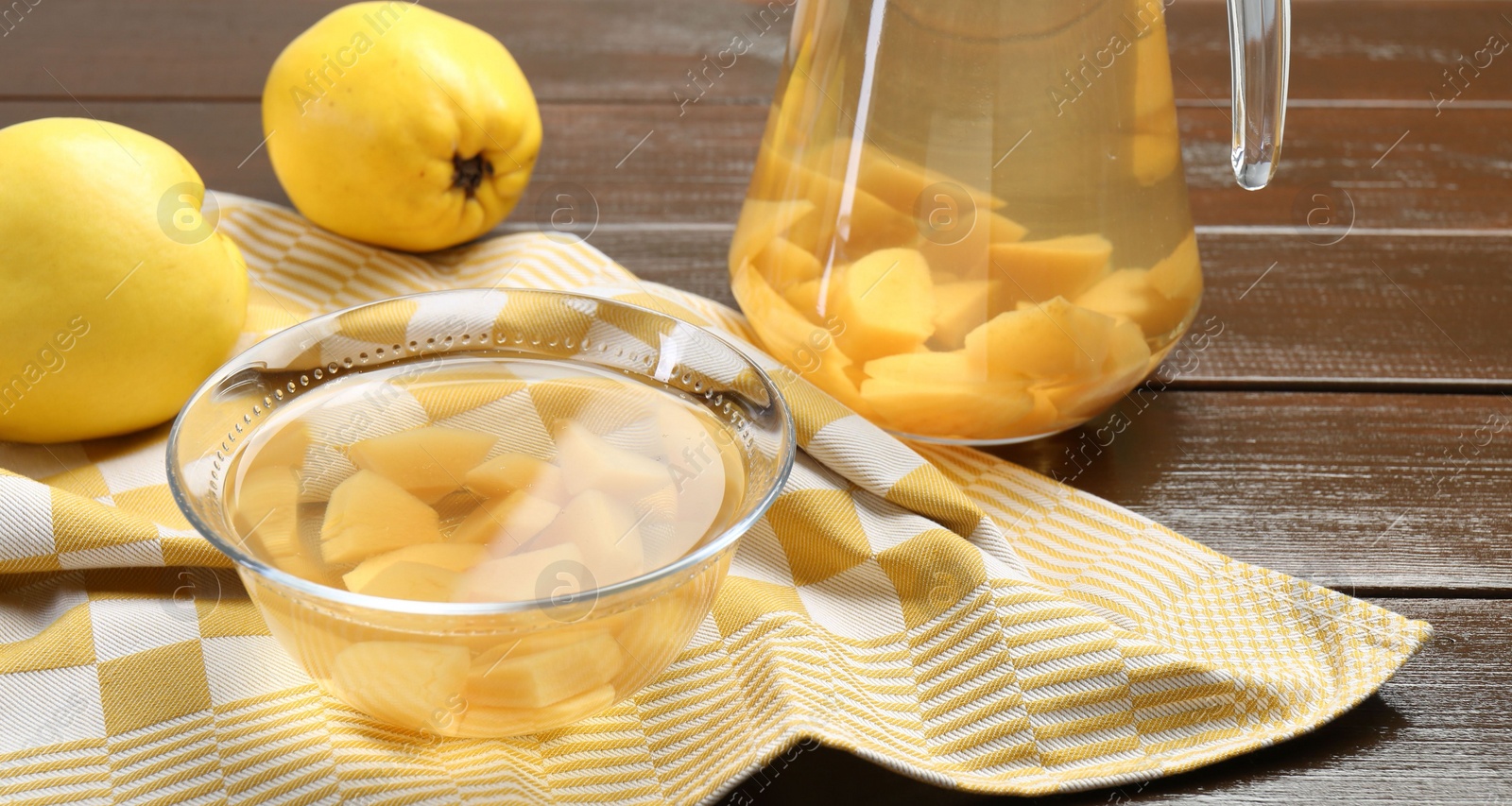 Photo of Delicious quince drink and fresh fruits on wooden table, closeup