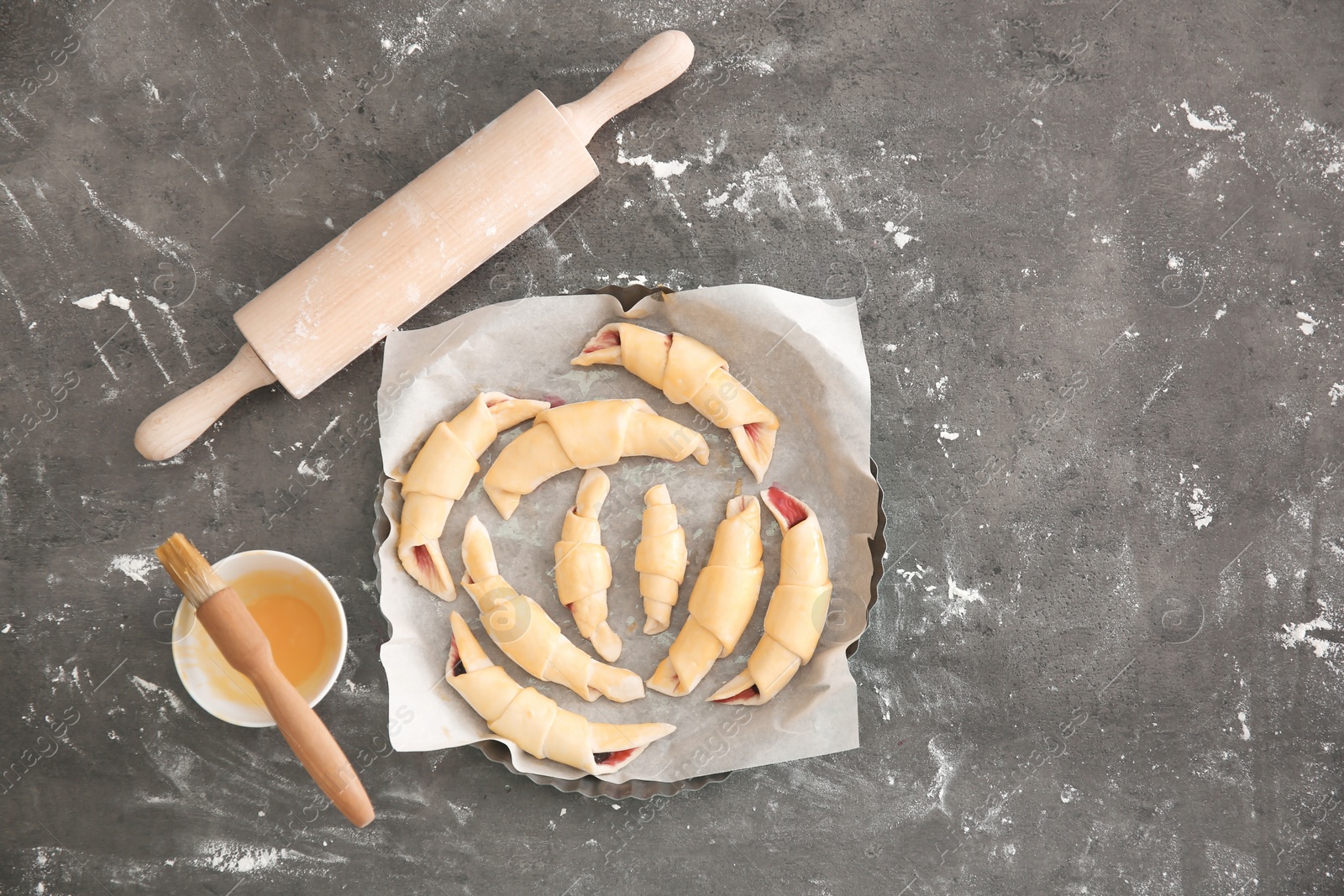 Photo of Baking dish with raw croissants on table, top view