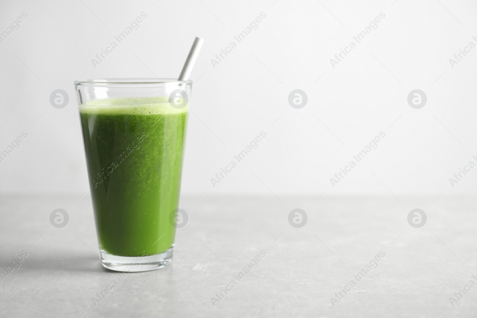 Photo of Glass with delicious detox juice on table