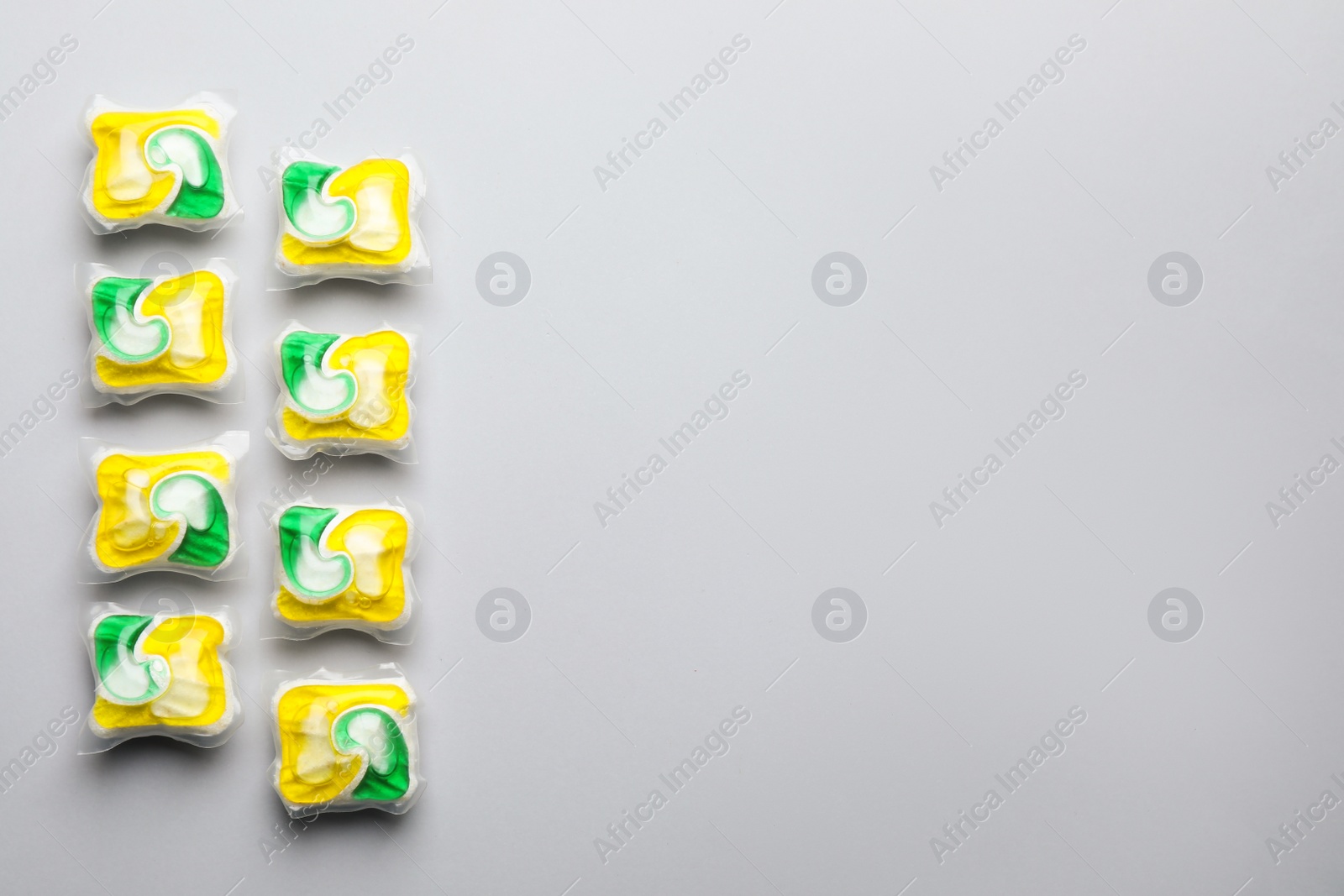 Photo of Many dishwasher detergent pods on light grey background, flat lay. Space for text