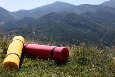 Photo of Rolled sleeping pads on grass in mountains, space for text