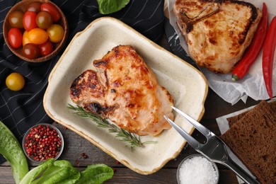 Photo of Tasty marinated meat, rosemary and spices on wooden table, flat lay