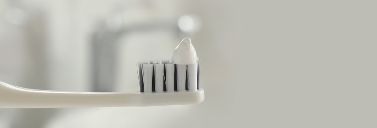 Image of Brush with toothpaste in bathroom, space for text. Banner design