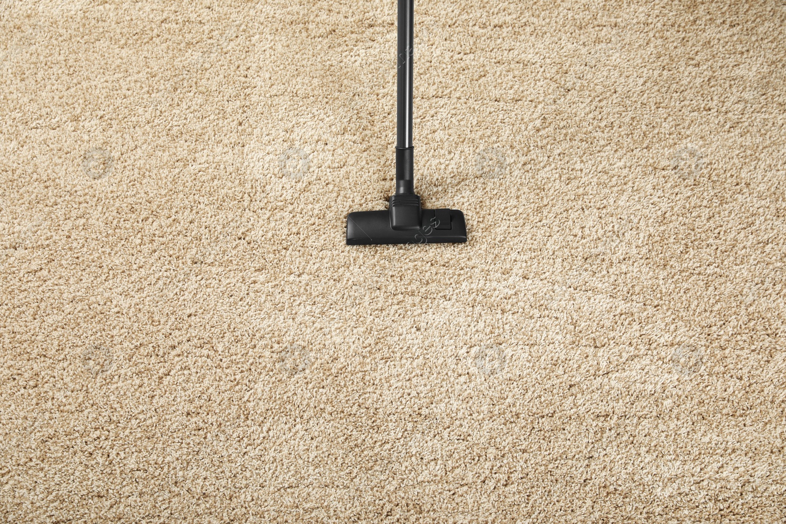 Photo of Removing dirt from beige carpet with modern vacuum cleaner, top view. Space for text