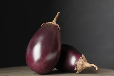 Photo of Ripe purple eggplants on wooden table, closeup