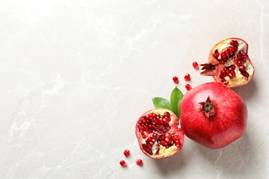 Photo of Composition with ripe pomegranates and space for text on light background, top view