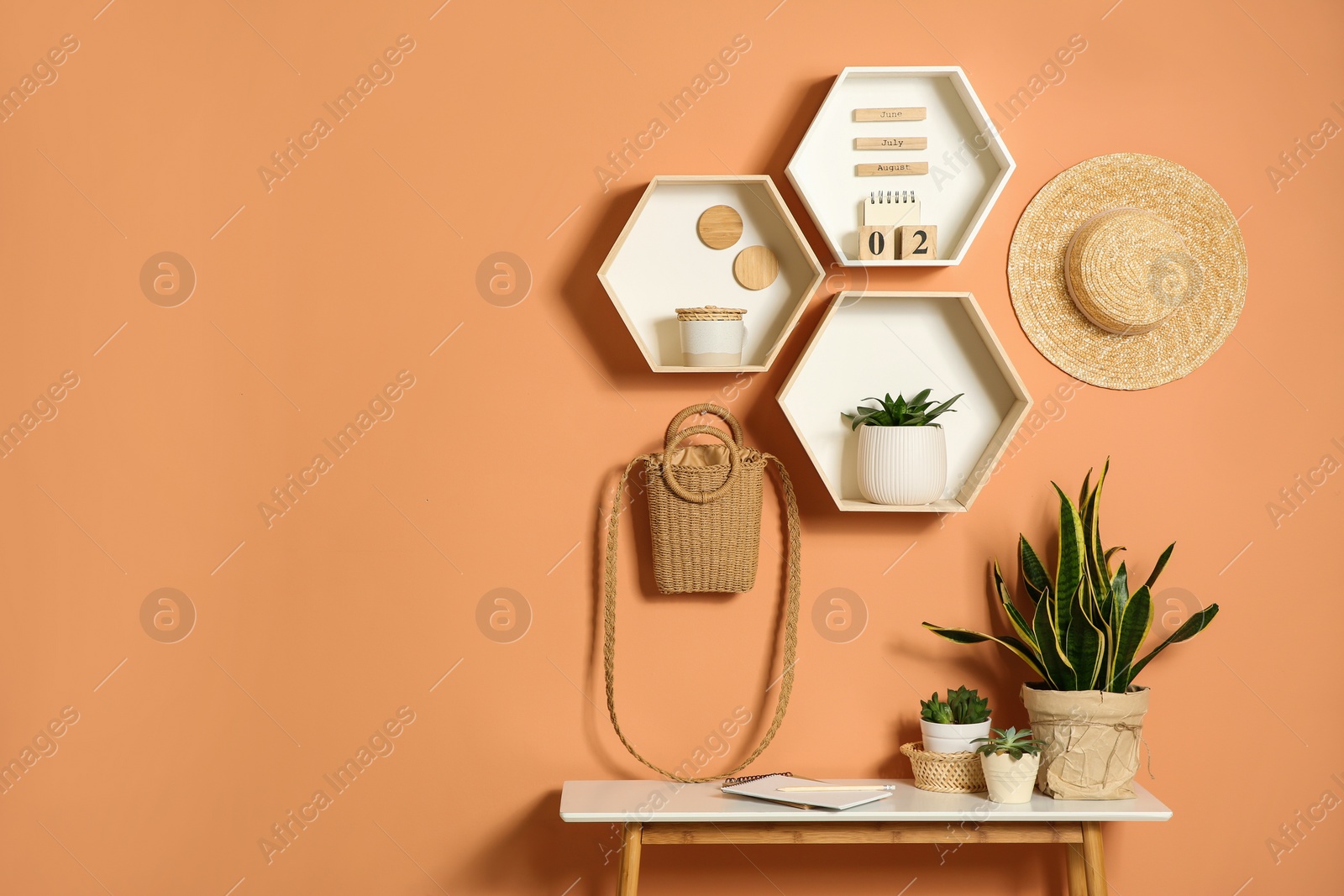 Photo of Shelves and table with decorative elements on color wall. Space for text