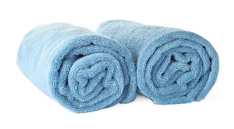 Photo of Rolled clean blue towels on white background