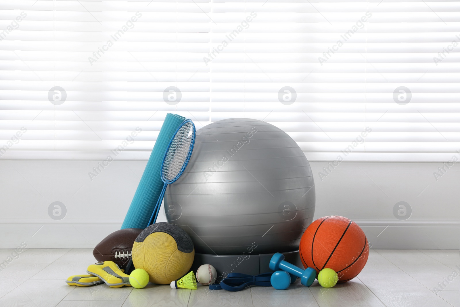 Photo of Set of different sports equipment on white floor indoors