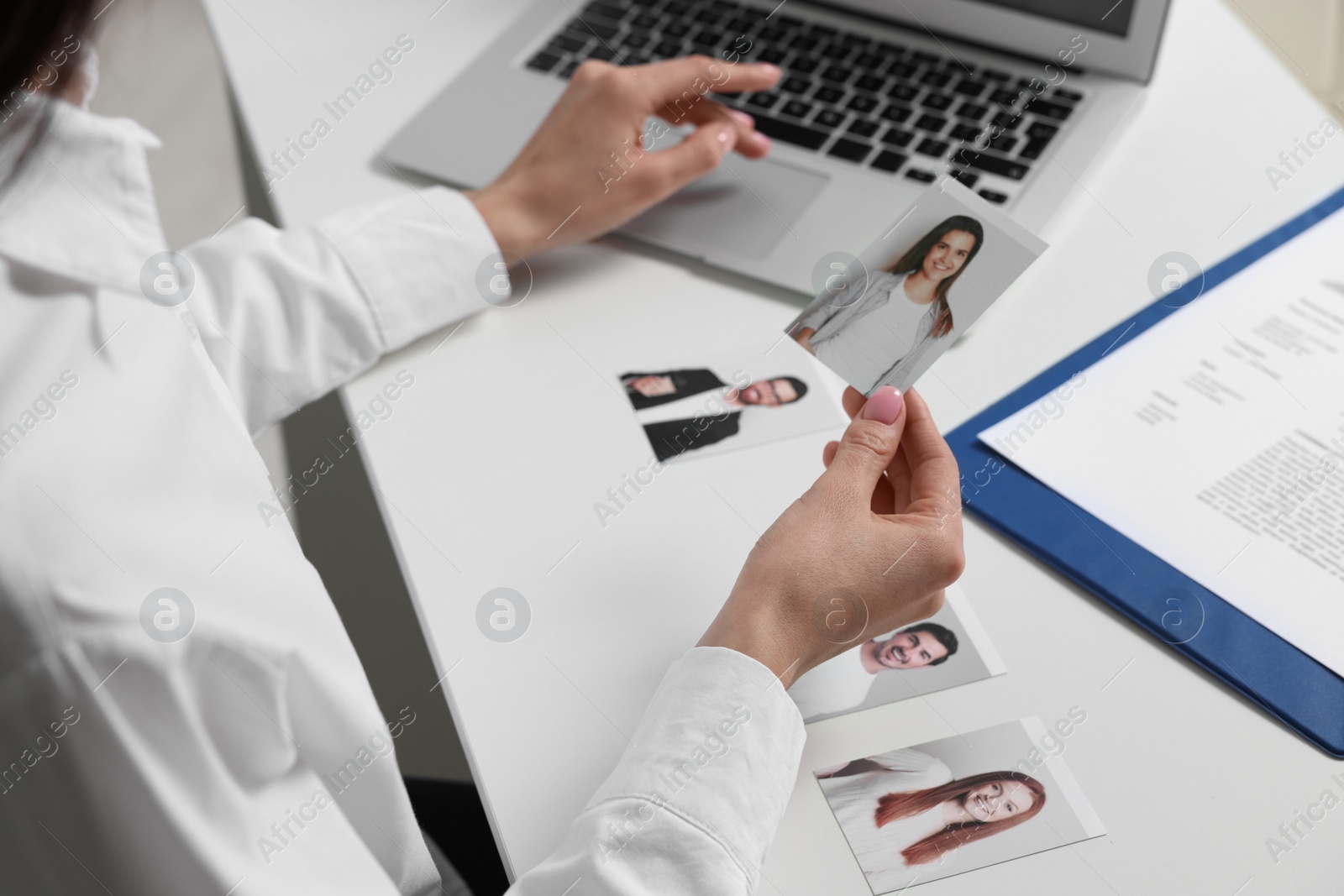 Photo of Human resources manager choosing employee among different applicants at table, closeup