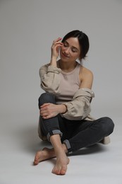 Portrait of beautiful woman on light grey background