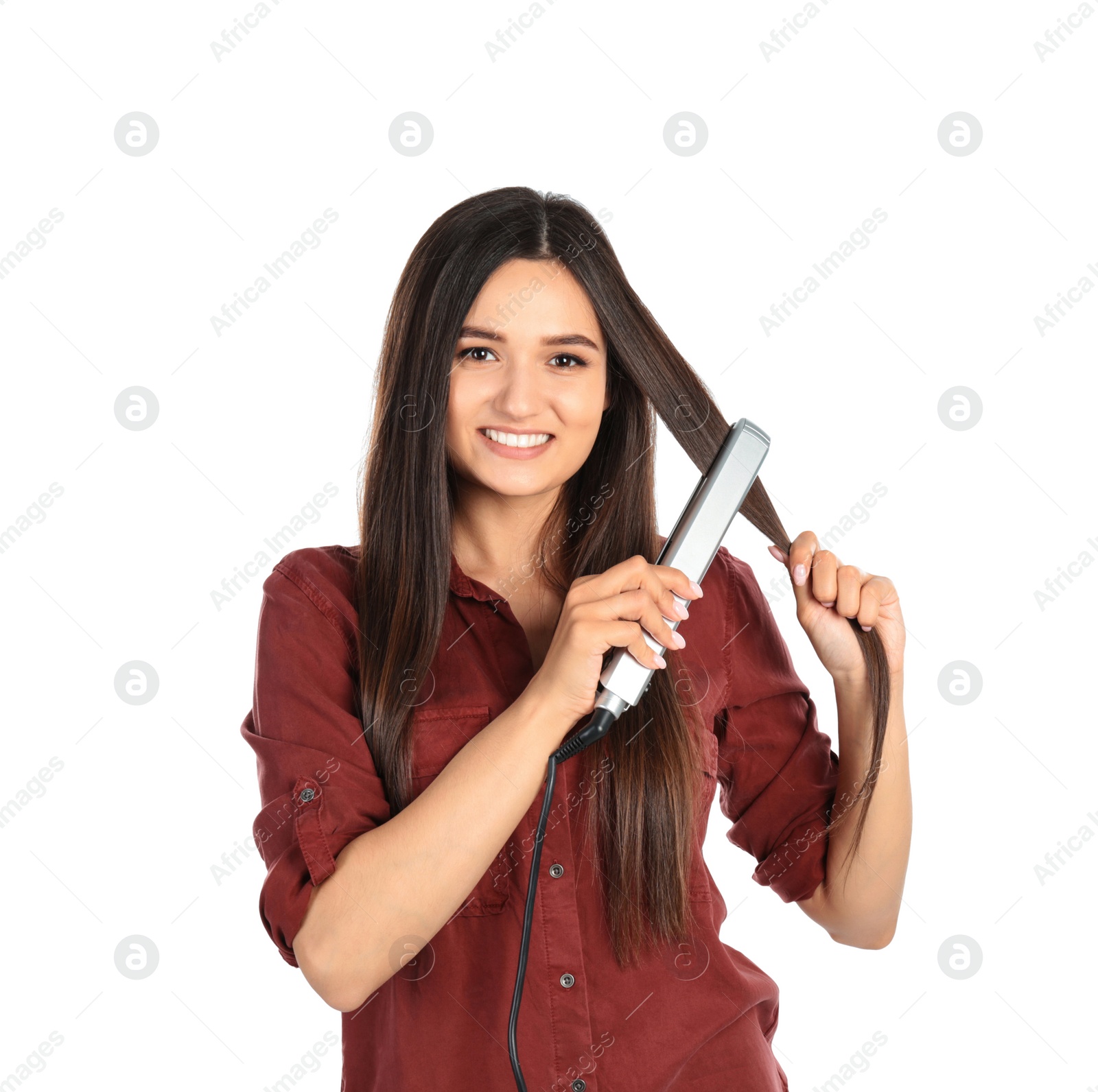 Photo of Young woman using hair iron on white background