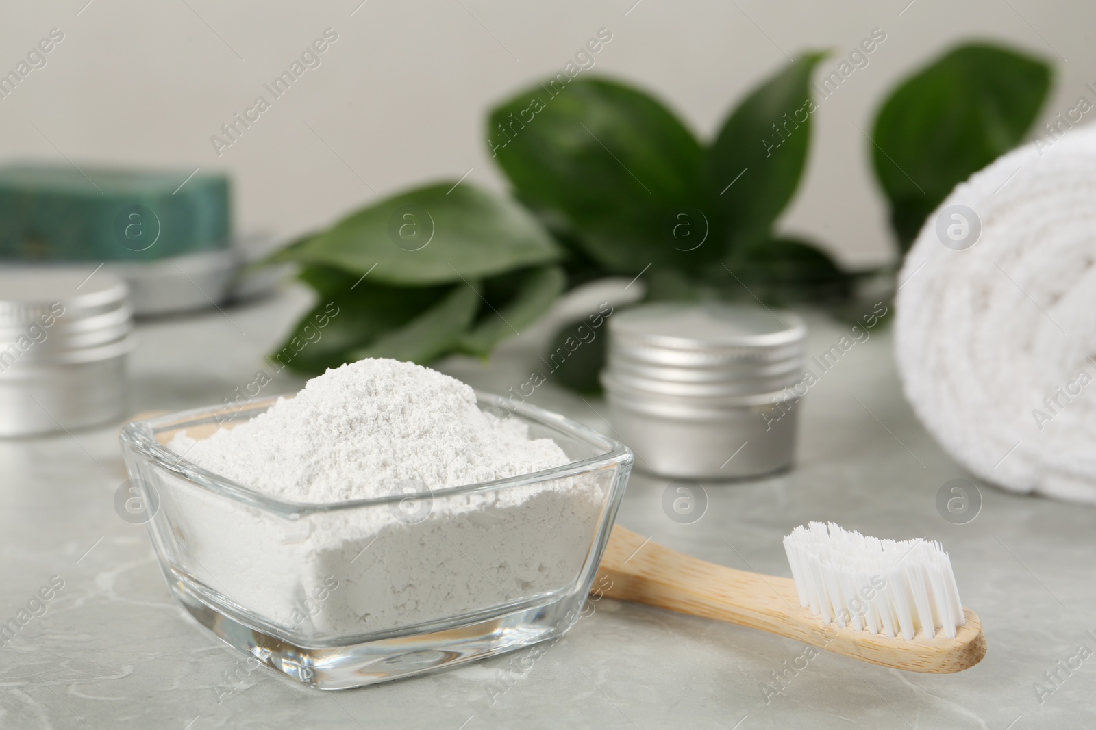 Photo of Tooth powder and brush on light grey marble table, closeup