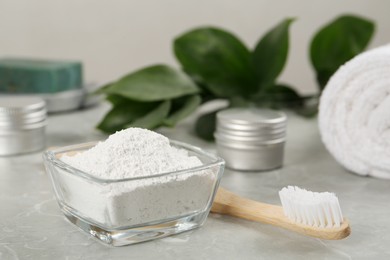 Tooth powder and brush on light grey marble table, closeup