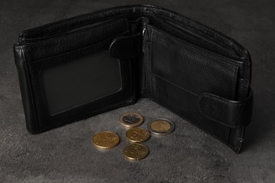 Photo of Poverty. Black wallet and coins on grey table