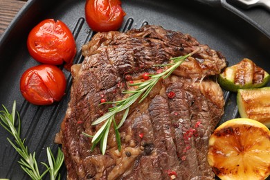 Photo of Delicious grilled beef steak and vegetables in frying pan, top view