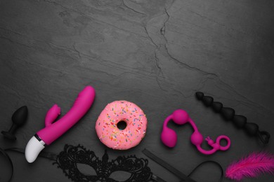 Photo of Flat lay composition with sex toys on black background. Space for text