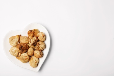 Photo of Plate of dried figs on white background, top view with space for text. Healthy fruit