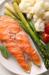 Photo of Healthy meal. Grilled salmon steak and vegetables on white table, top view