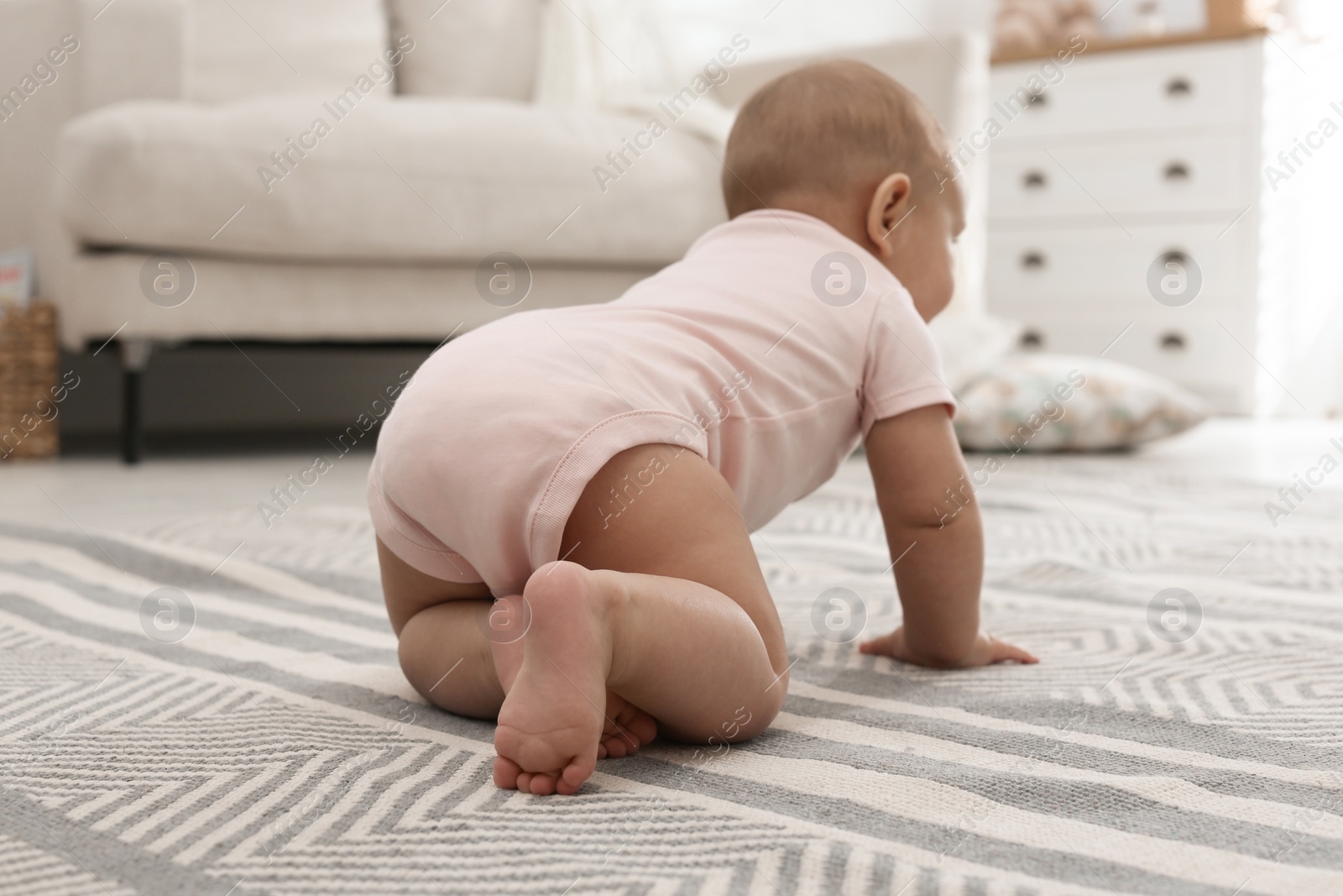 Photo of Cute baby crawling at home, focus on legs