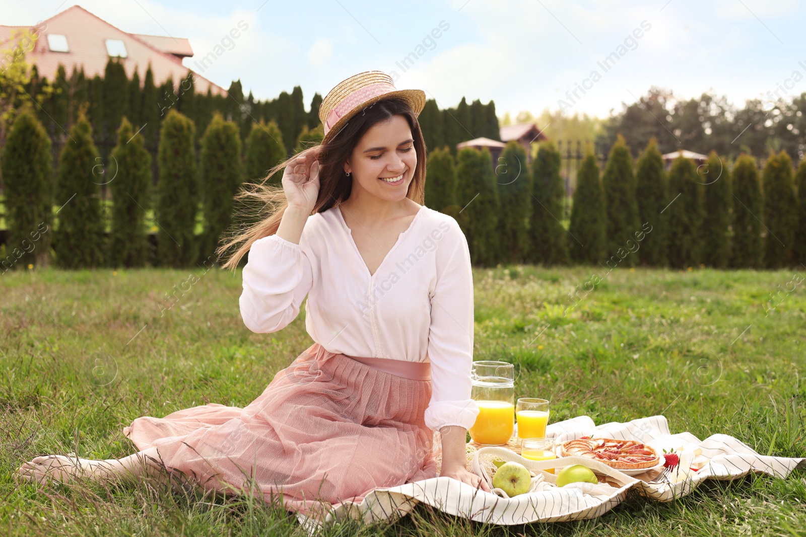 Photo of Young woman having picnic outdoors on summer day