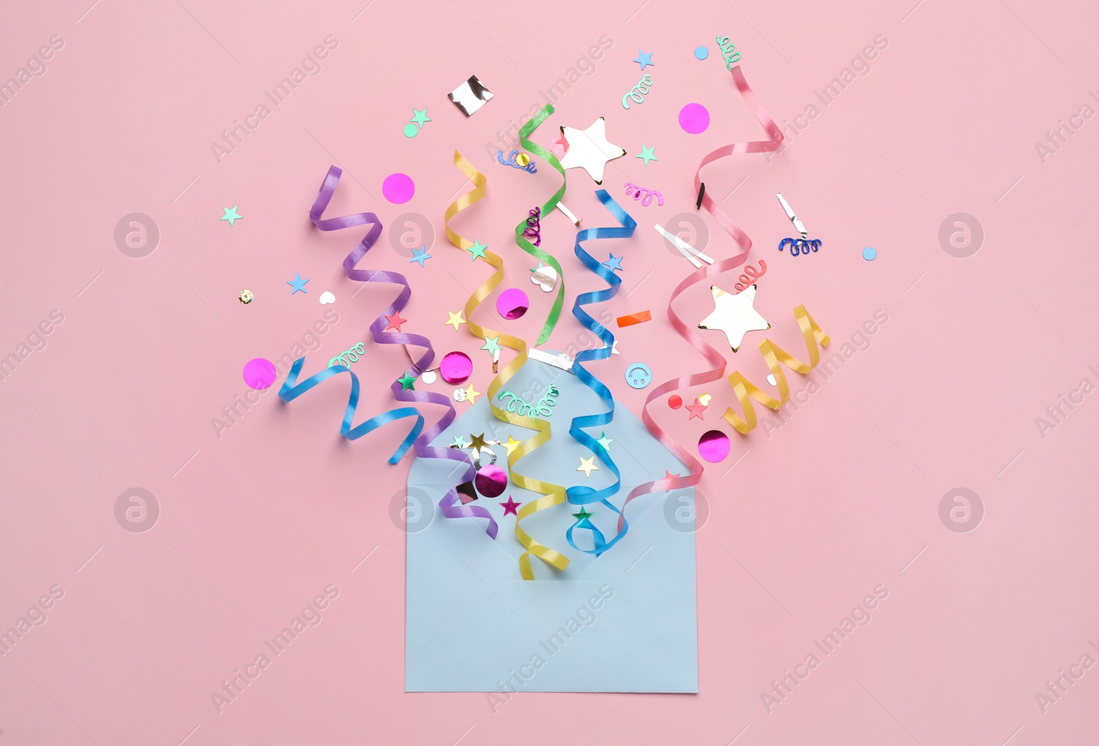 Photo of Envelope with confetti and serpentine streamers on pink background, top view. Surprise party